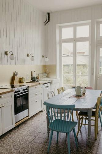 une cuisine avec une table et des chaises dans une cuisine dans l'établissement Charming 1920S House In Picardy, 2H From Paris, à Sainte-Croix