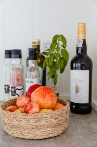 a basket filled with apples and bottles of wine at Fresh Air On Open Terrace With View in Hejls