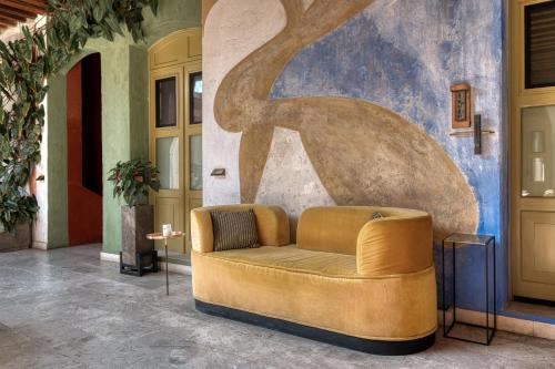 a brown couch in a room with a wall at Pug Seal Oaxaca in Oaxaca City