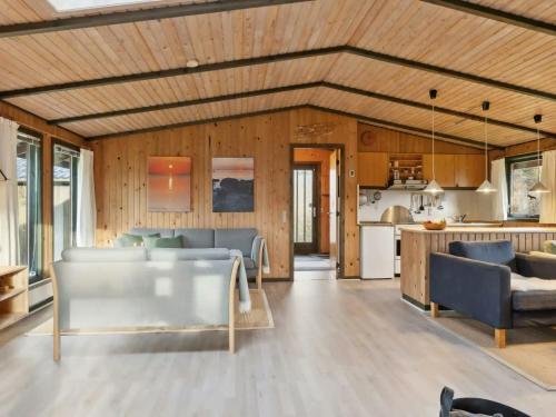 a kitchen and living room with wooden walls at Charming Wooden Summer House In Trend in Løgsted