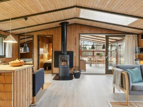 a living room with a fireplace in a house at Charming Wooden Summer House In Trend in Løgsted