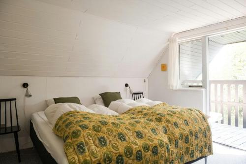 a bedroom with a bed with a yellow blanket at Summer House For The Big Family Close To The Fjord in Agger
