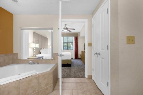a bathroom with a tub and a bedroom with a bed at Resort Style Condo 4 miles from Disney in Orlando