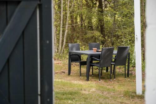 a black table and chairs with a cup on it at Summer House For The Big Family Close To The Fjord in Agger