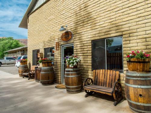 a building with barrels and a bench in front of it at Rustic Inn in Moab