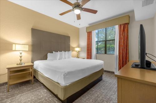 a bedroom with a bed and a flat screen tv at Resort Style Condo 4 miles from Disney in Orlando
