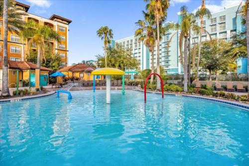 a pool at a resort with palm trees and buildings at Resort Style Condo 4 miles from Disney in Orlando