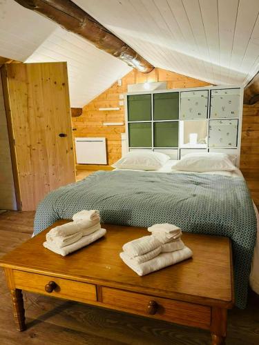 - une chambre avec un lit et des serviettes sur une table en bois dans l'établissement Historic Mill In The Heart Of Black Mountain, à Caudebronde