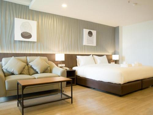 a hotel room with a bed and a couch at B2 Hat Yai Rat Uthit Boutique & Budget Hotel in Sathani Hat Yai