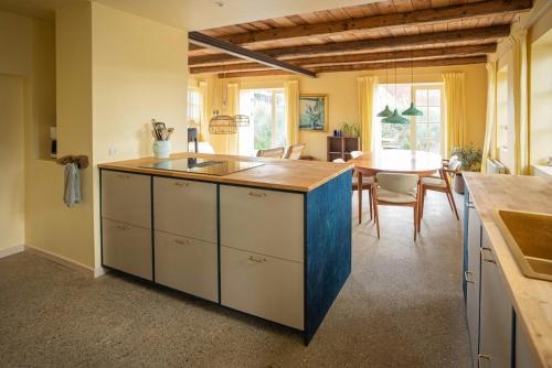 a kitchen with a island with a sink and a table at Historic Fisherman's Gem With Twist In Klitmøller in Torsted