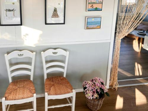 two white chairs in a room with a vase of flowers at Romantic Summerhouse With Seaview in Kolding