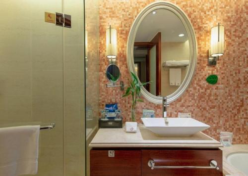 a bathroom with a sink and a mirror at Xiangsheng Century Hotel Zhuji in Shaoxing
