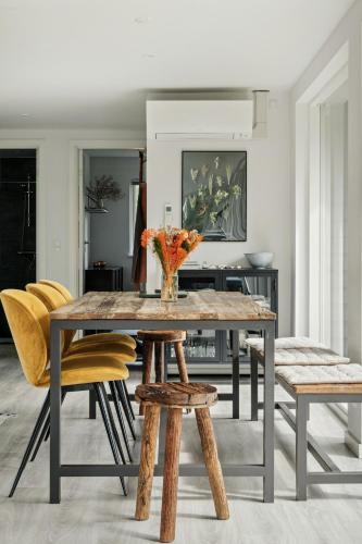 a dining room with a table and yellow chairs at Beautiful Tranquil Home By Fjord Near Copenhagen in Holbæk