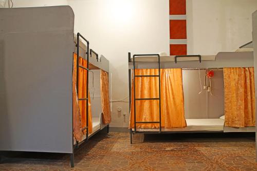 a room with two bunk beds with orange curtains at Mario's Travellers Inn in Coron