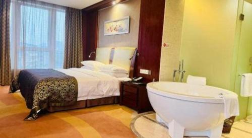 a bathroom with a tub and a bed and a bath tub at Jinhua World Trade Hotel in Jinhua