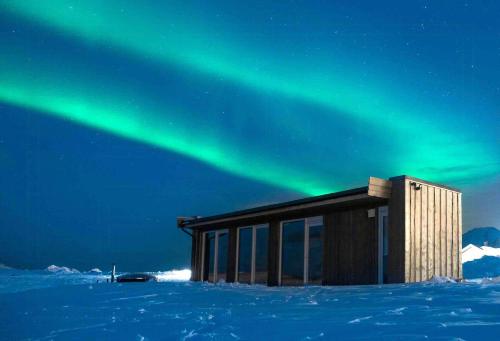 un edificio con la aurora en el cielo en Unique Small Cabin With Sauna View In Lofoten, en Ramberg