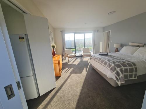 a bedroom with a bed and a large window at Sweet Home in Rolleston