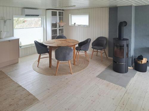 a kitchen with a table and chairs and a stove at Cottage Charm Near Lønstrup Lighthouse in Lønstrup
