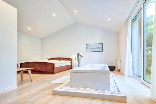 ein Schlafzimmer mit einem Bett und einer Badewanne in der Unterkunft Renovated Chalet In The Heart Of Nature In Vendée in La Gaubretière