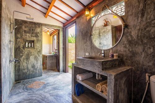 y baño con lavabo y espejo. en Red Flower Cottages Homestay, en Hoi An