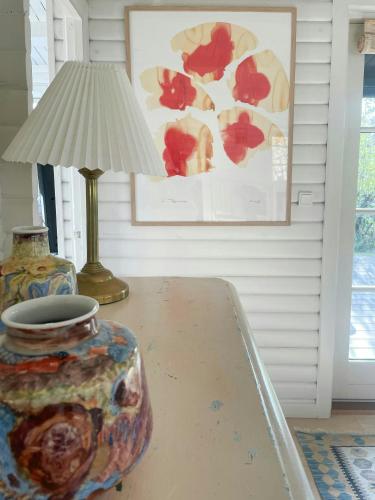 a table with a lamp and a vase on it at Cozy Summer House In Rørvig With Historical Charm in Rørvig