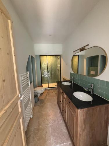 La salle de bains est pourvue de 2 lavabos, d'un miroir et de toilettes. dans l'établissement Domaine Daulone plein sud, à Vaison-la-Romaine
