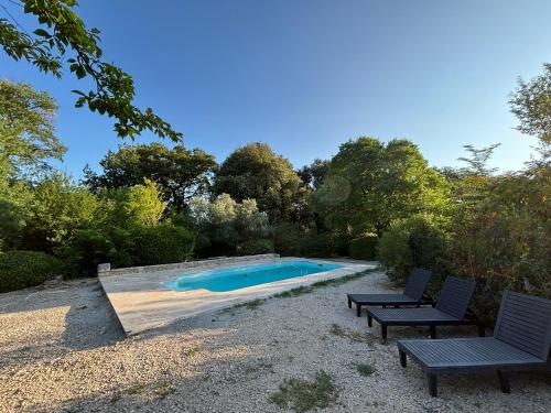 - une piscine avec 2 chaises à côté dans l'établissement Domaine Daulone plein sud, à Vaison-la-Romaine