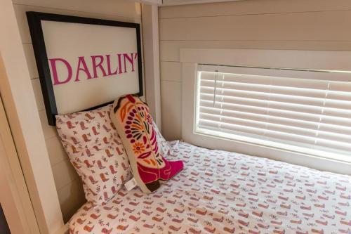a bedroom with a bed and a window with a donation sign at Little Dolly (In The Pines at KY Lake) 105 Pine Grove Lane, Dover, TN 37058 in Dover