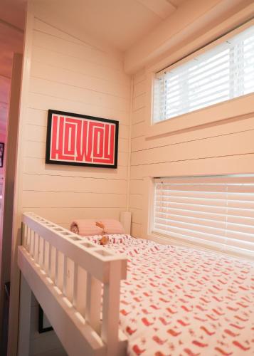 a bedroom with a bed with a sign on the wall at Little Dolly (In The Pines at KY Lake) 105 Pine Grove Lane, Dover, TN 37058 in Dover