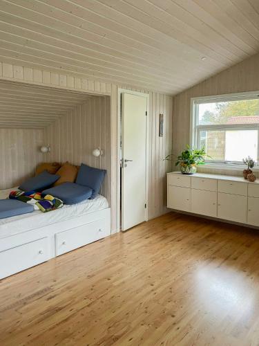 Un dormitorio grande con una cama y una ventana. en Cozy Summer House Near Kattegat, en Saeby