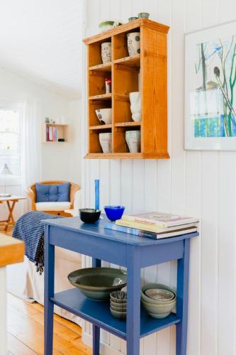 a blue table with bowls on it in a living room at Renovated House With Charm And Outdoor Shower in Hals