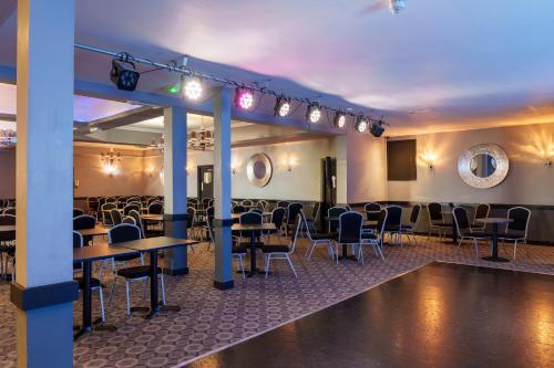 a room with tables and chairs in a room at The Royal Boston Hotel by Compass Hospitality in Blackpool