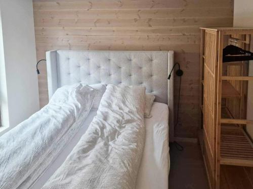 a bedroom with a white bed and a wooden shelf at Near-Sea Boat House With Panoramic Views in Sykkylven