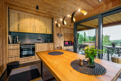 a kitchen with a wooden table and a large window at Treetop Loft In Harz National Park in Ilsenburg