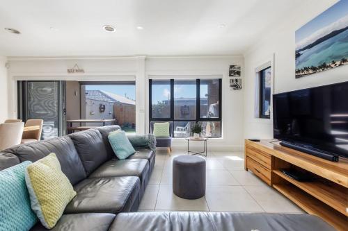 a living room with a couch and a flat screen tv at Sullivan Villa - Spacious Modern Escape by Rye Beach in Rye