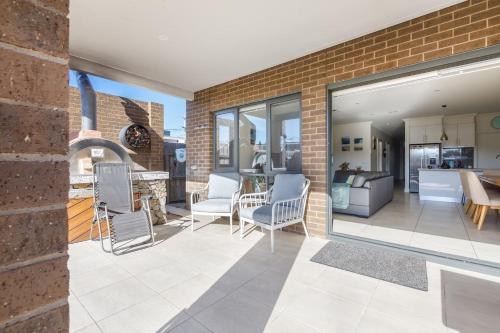 a patio with chairs and a living room at Sullivan Villa - Spacious Modern Escape by Rye Beach in Rye