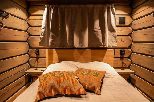 a bed in a wooden cabin with two pillows on it at Cabin With Great Fishing At Trysilfjellet in Jordet
