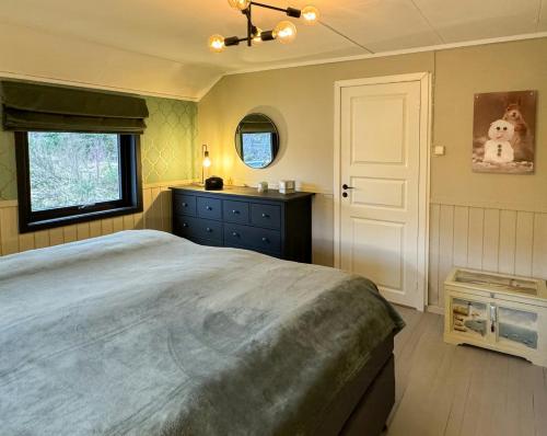 a bedroom with a large bed and a window at Charming Seaside Cabin With Amazing View in Hardbakke