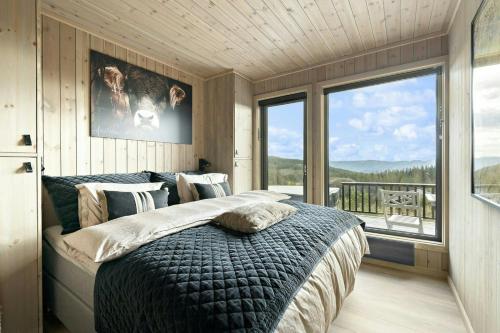 una camera da letto con un letto grande e una grande finestra di Norefjell Cottage With Sauna And Whirlpool a Noresund