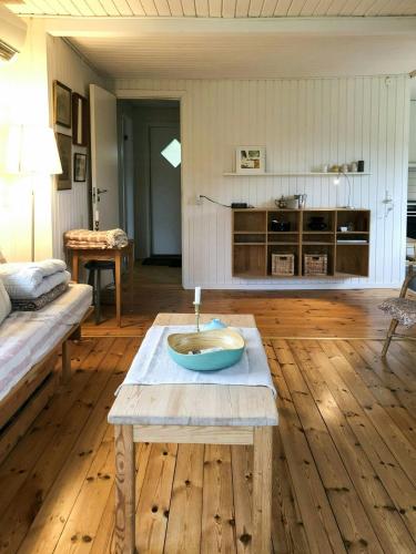 una sala de estar con una mesa y un sofá en Summer House Near The Beach On Møn, en Hovedskov