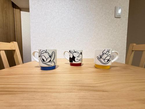 four coffee cups sitting on top of a wooden table at ZenAbode茨城 in Ryūgasaki