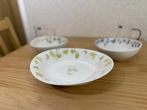 three bowls are sitting on a wooden table at ZenAbode茨城 in Ryūgasaki