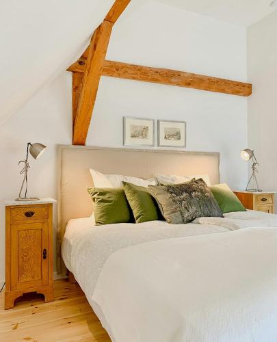 a bedroom with a white bed with green pillows at Cozy Holiday Home In The Mecklenburg Lake District in Hohen Demzin