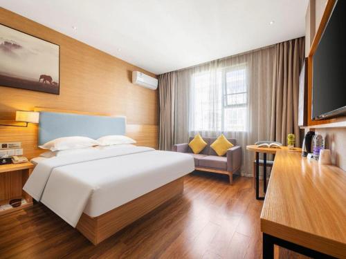 a bedroom with a large white bed and a couch at JTOUR Inn Guigang Life Port High-speed Railway Station in Guigang