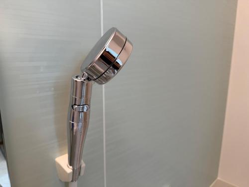 a shower head on a wall in a bathroom at ZenAbode茨城 in Ryūgasaki