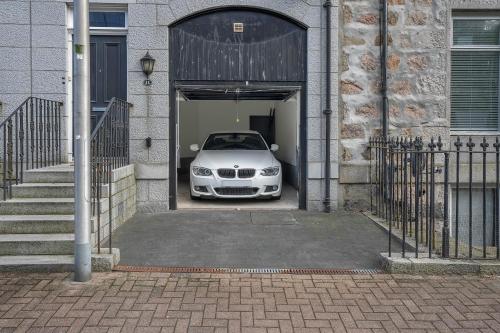 une voiture blanche est garée à l'intérieur d'un garage dans l'établissement Crimon Place Townhouse - Grampian Lettings Ltd, à Aberdeen