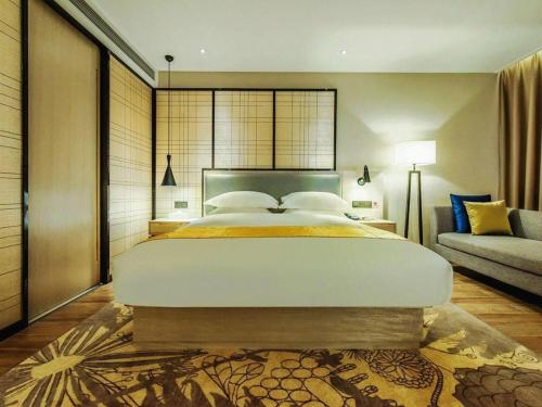 a bedroom with a large bed and a couch at Echarm Hotel Anshun High-speed Railway Station Jichang Road in Anshun