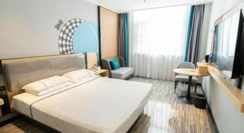 a bedroom with a large white bed and a tv at City Comfort Inn Yingcheng Railway Station Shanghe Square in Xiaogan