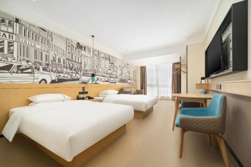a hotel room with two beds and a flat screen tv at City Comfort Inn Nanning International Exhibition Jinhu Plaza in Nanning