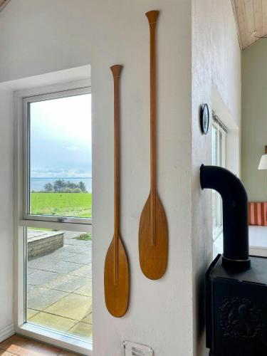 two woodenoons hanging on a wall next to a stove at Summer House With Panoramic View Near Doverodde in Doverodde